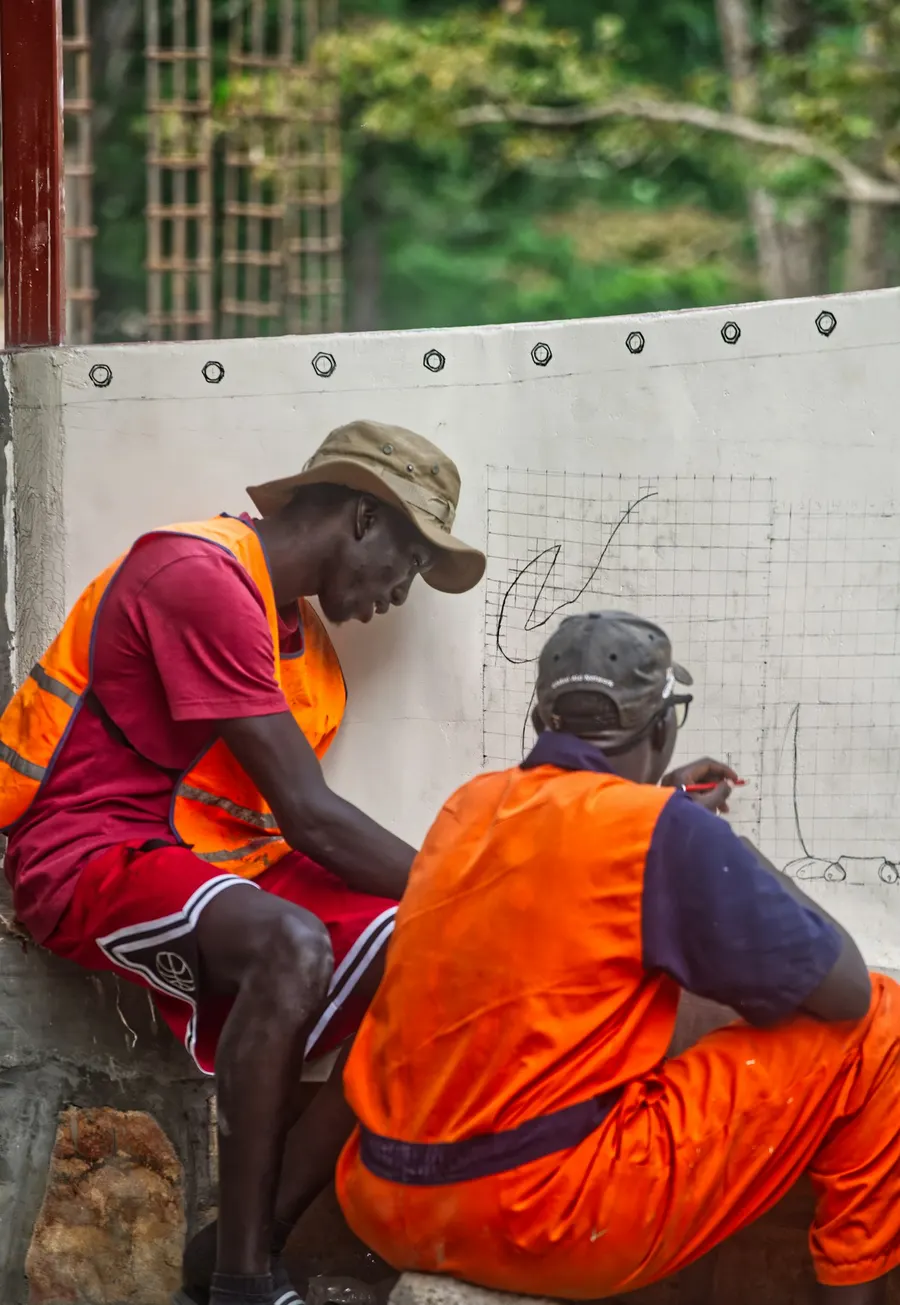 Two workers in safety vests reviewing plans on site