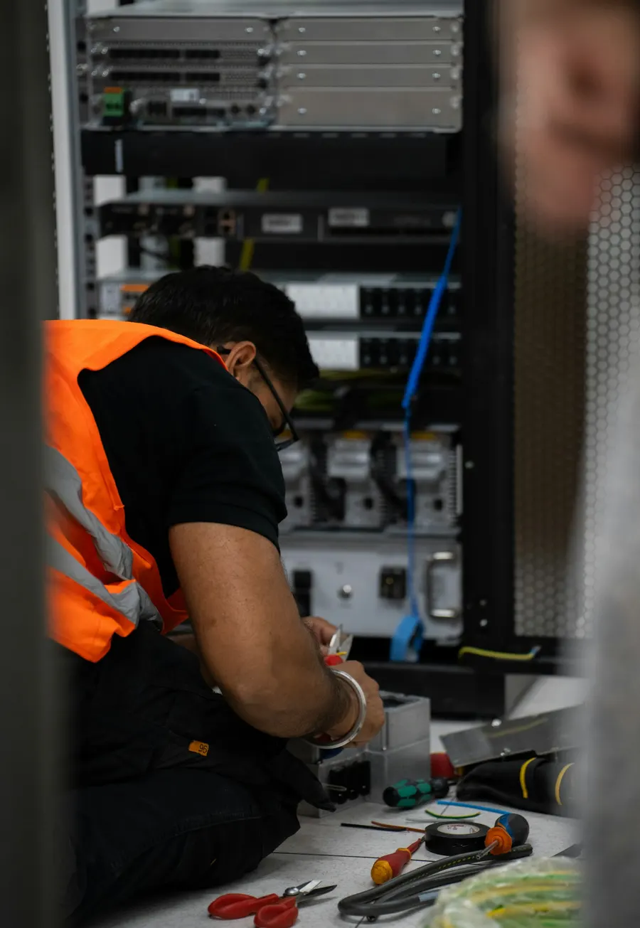 Technician wiring equipment in a server rack