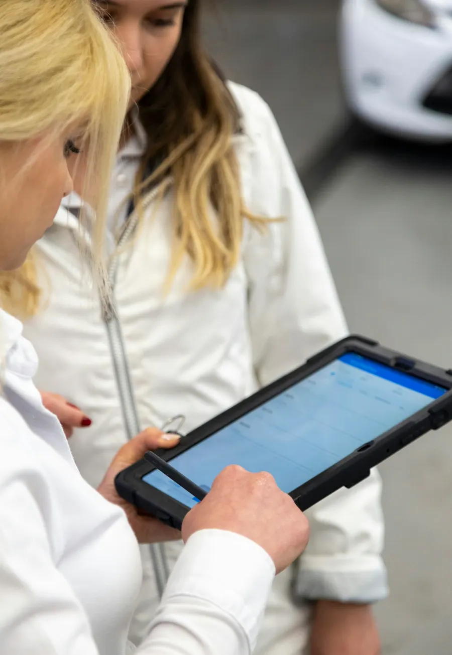 Two women reviewing a schedule on a tablet