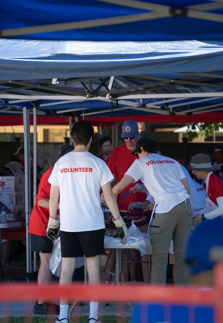 Volunteers sorting supplies under a tent