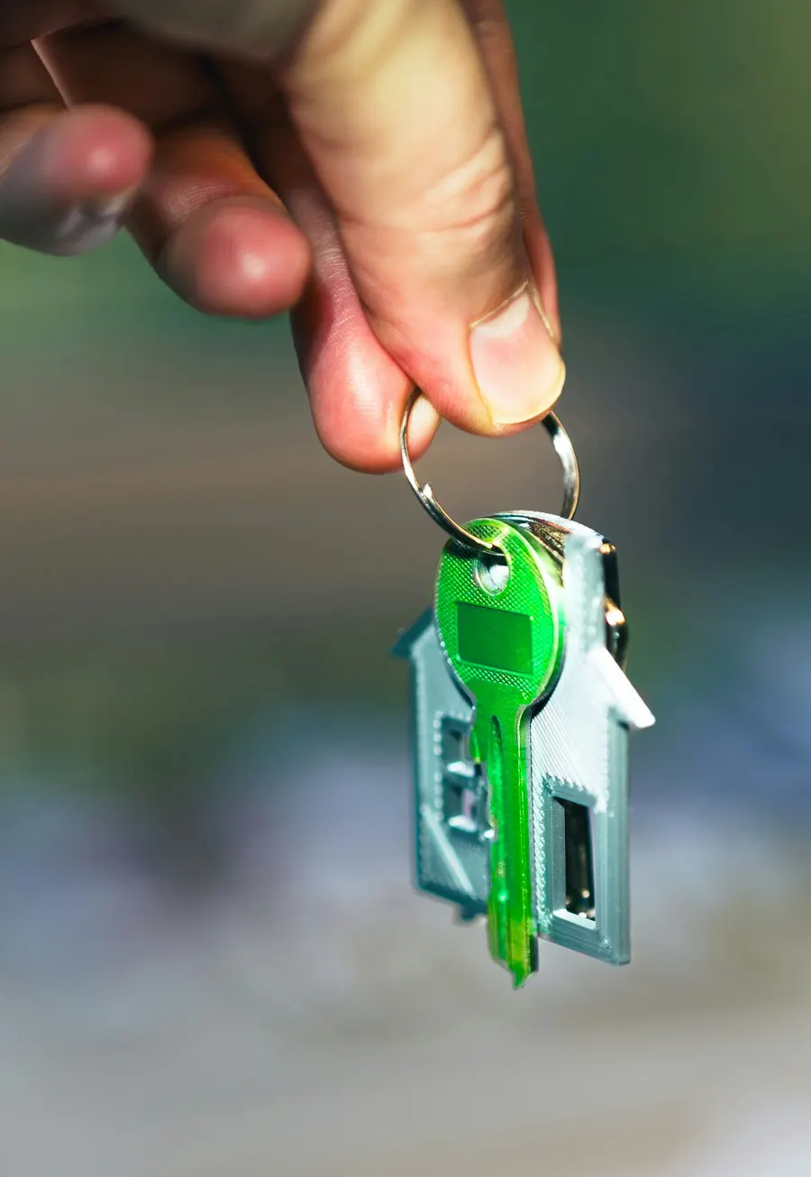 Hand holding a house key on a keychain